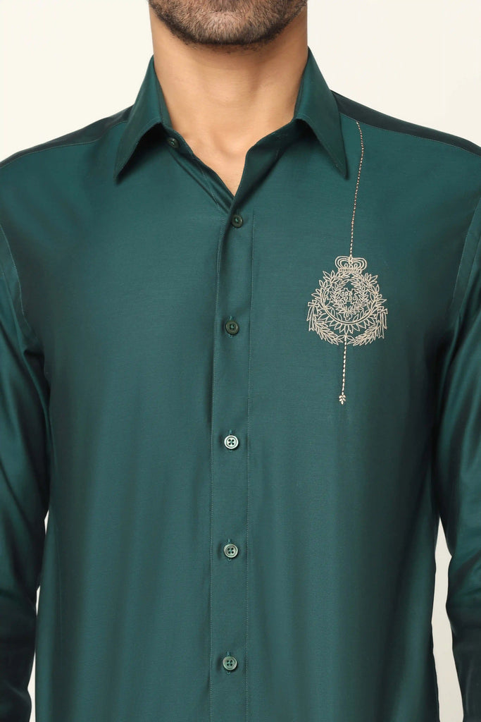 Green Designer shirt made using 100% giza cotton. It features a regal crest on its left chest side.