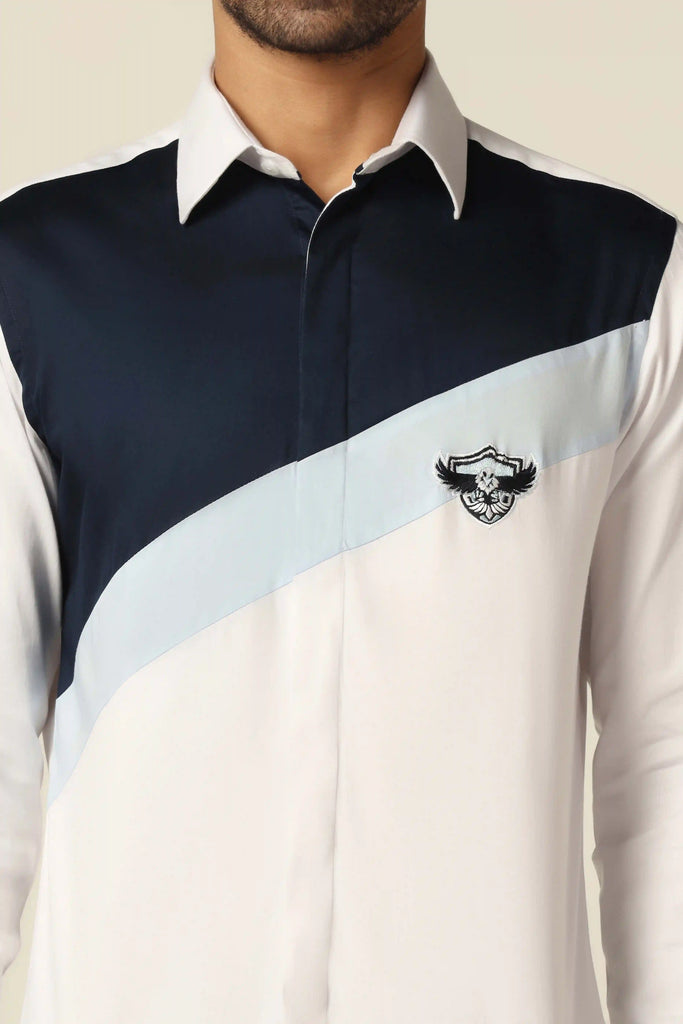 Experience luxury with our 100% Giza Cotton shirt. Navy blue and sky blue paneling across the chest, adorned with a crest embroidery on the left side.