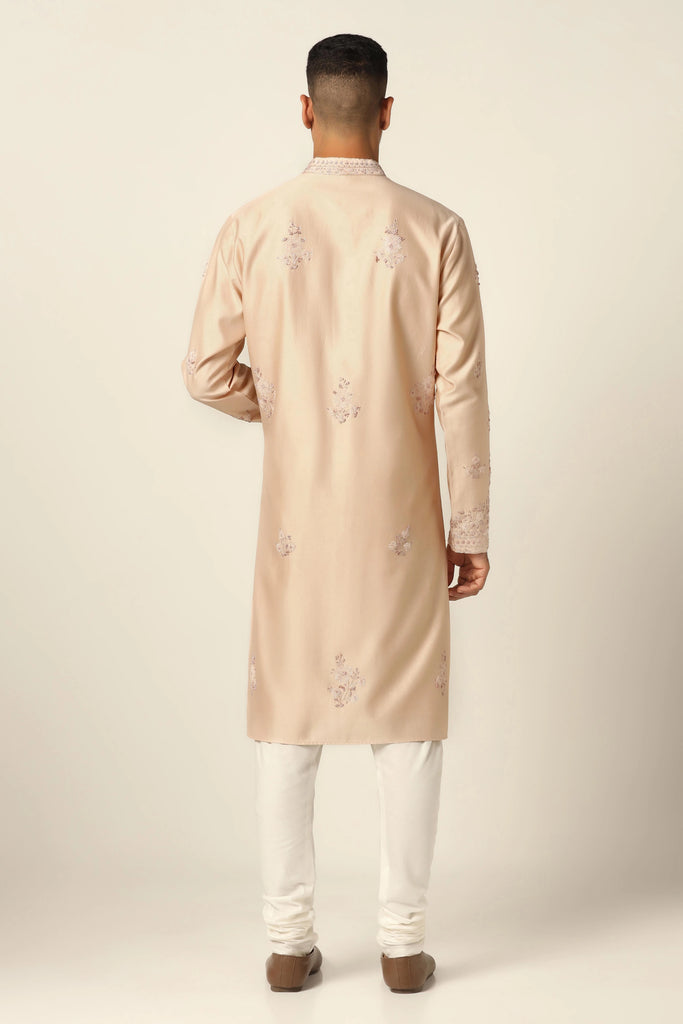 Elegance meets comfort in this Chanderi silk kurta pajama set. Adorned with intricate tonal embroidery, the peach kurta is paired with an off-white churidar pajama.