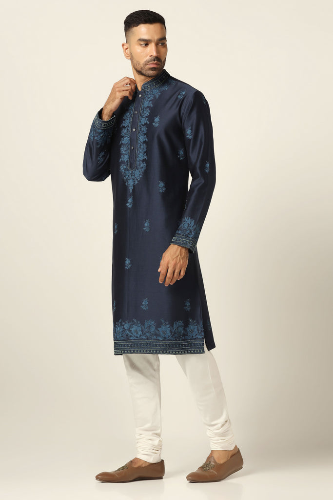Elevate your style with our Chanderi Silk kurta set, adorned with intricate thread embroidery on the neck, button placket, and small motifs. Paired with an off-white churidar pajama for a refined look.