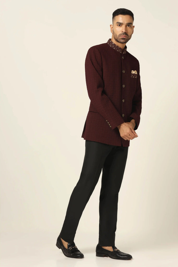 Elevate your style with our textured Bandhgala suit, adorned with golden buttons and matching embroidery on the collar and chest pocket. Paired with jet black trousers for a refined look.