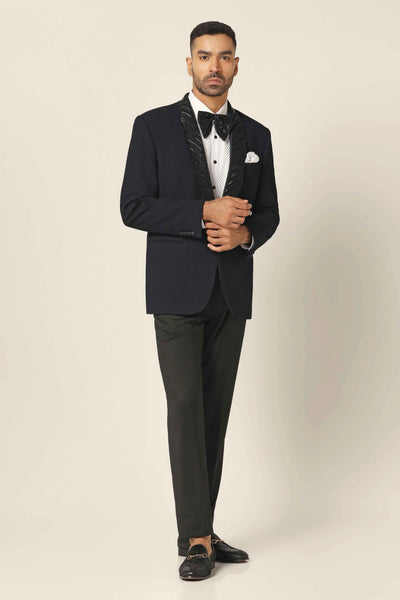 Elevate your formal look with our Navy Tuxedo. Shawl collar, subtle embroidery, contrasting texture. Complete with Black Trouser. Shirts & bows sold separately.