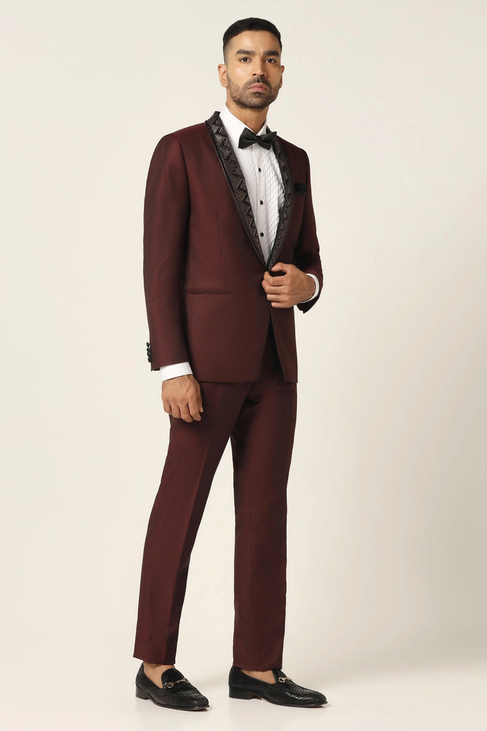 Elevate your style with our Wine Tuxedo. Satin shawl collar, subtle embroidery. Coat crafted from wine-textured fabric. Complete with matched Trouser.