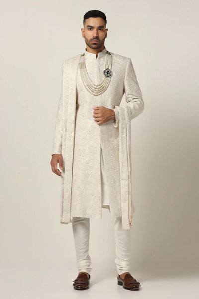 Indulge in luxury with our Raw silk Sherwani set, adorned with hand + machine embroidery. Complete with Kurta Pajama ensemble for timeless elegance.