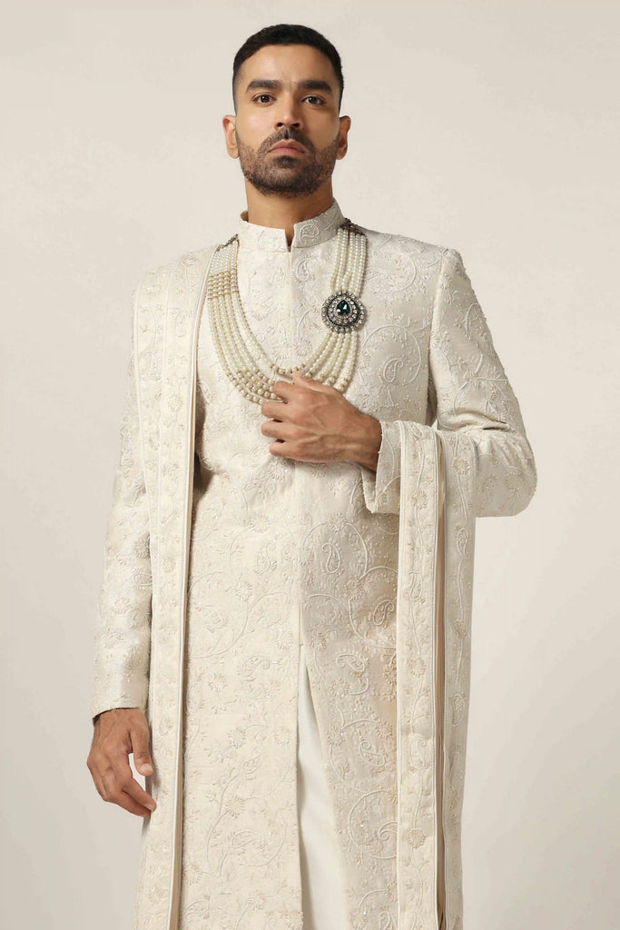Indulge in luxury with our Raw silk Sherwani set, adorned with hand + machine embroidery. Complete with Kurta Pajama ensemble for timeless elegance.