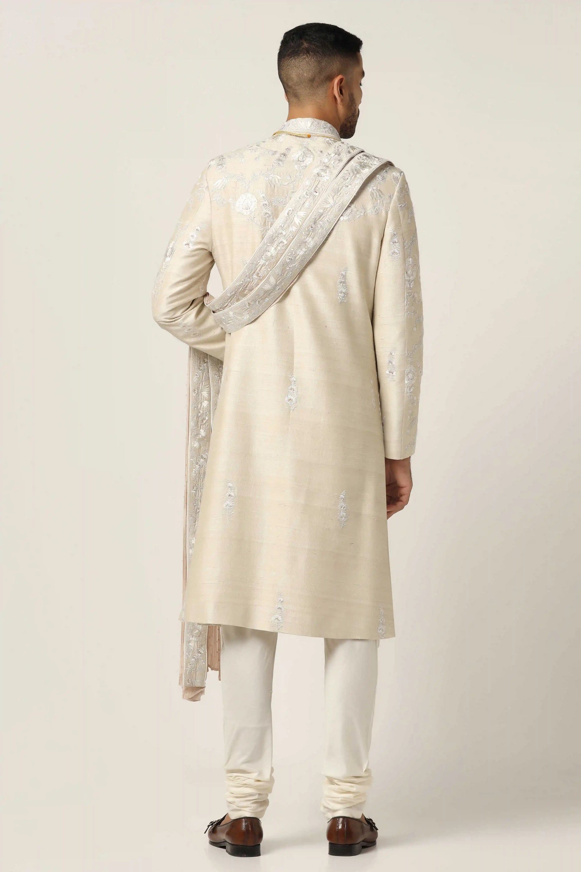 Crafted from raw silk, this Sherwani exudes elegance with intricate machine embroidery. Shop Now!