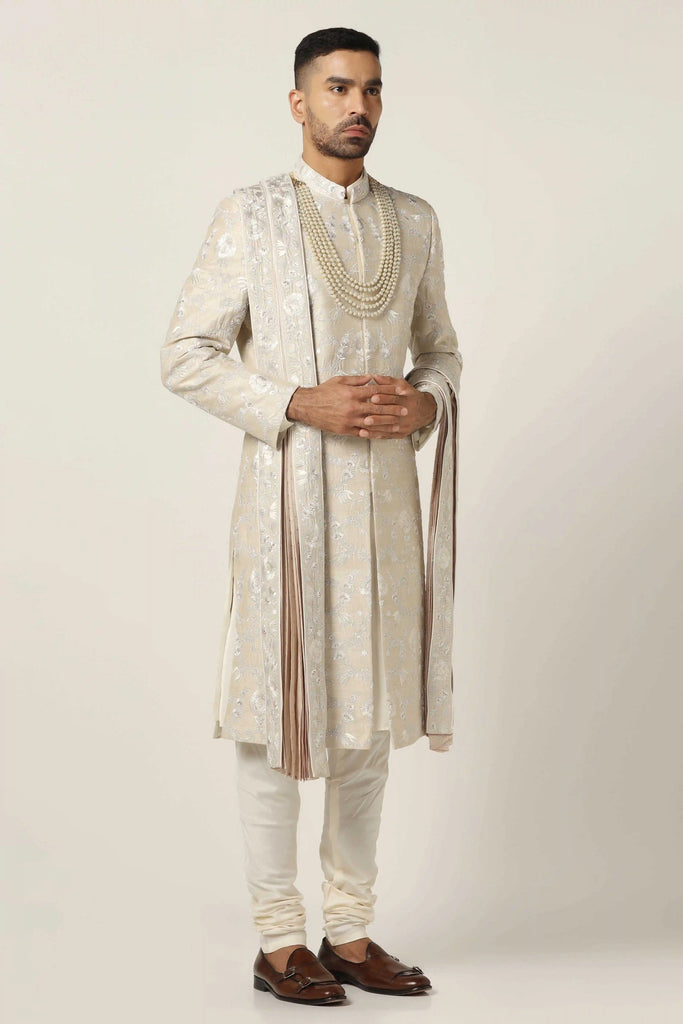 Crafted from premium Raw silk, this Sherwani set exudes elegance with intricate machine embroidery. Complete with a classic Kurta pajama ensemble for a timeless appeal.