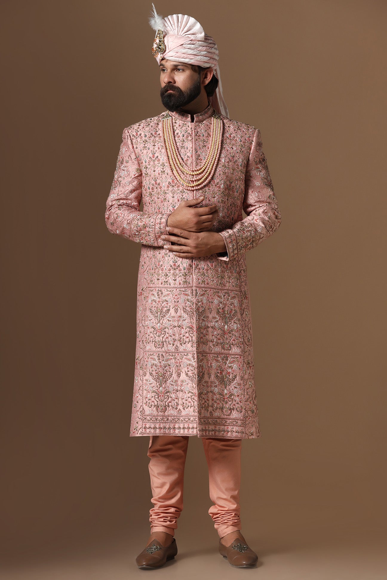 This peach Sherwani is highlighted by intricate floral embroidery across the garment. Shop Now!