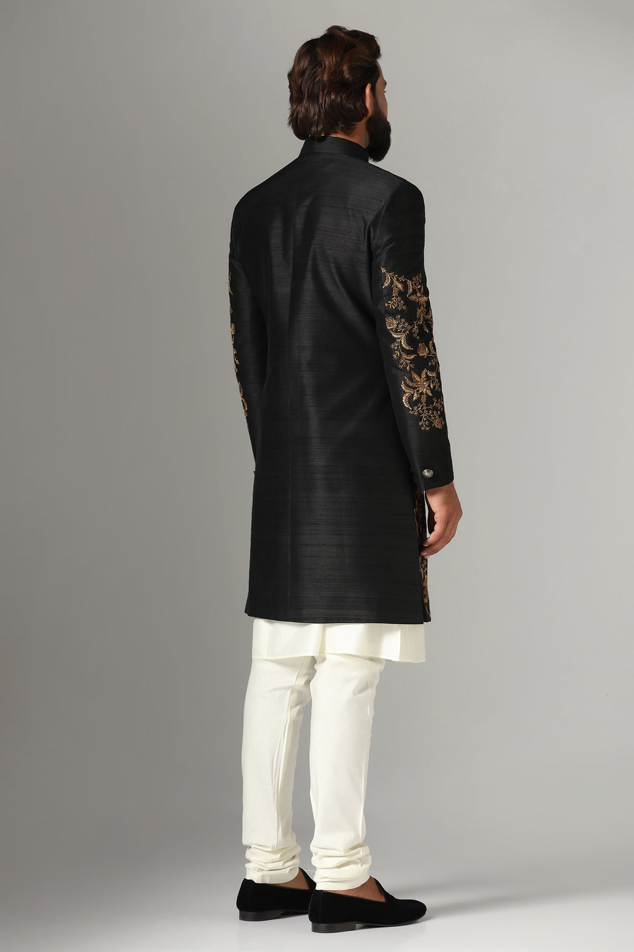 This black raw-silk Indowestern is highlighted with golden embroidery. Shop Now!