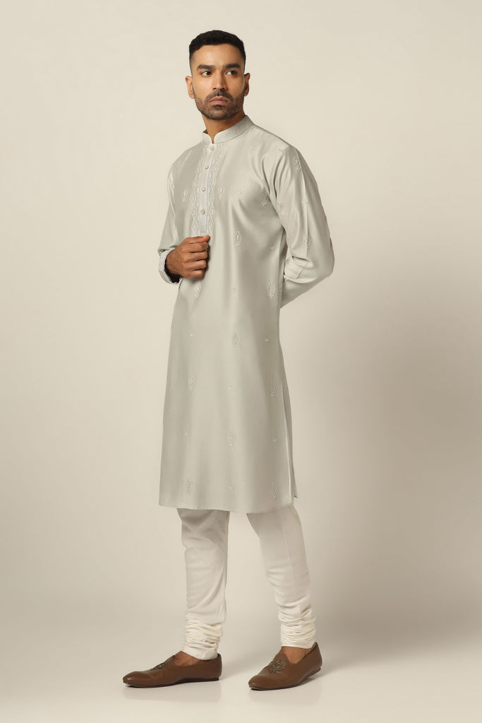 Dress in exquisite style with our Chanderi Silk kurta pajama set, featuring intricate thread/machine embroidery throughout. Complete with matching white pajamas for a refined ensemble.
