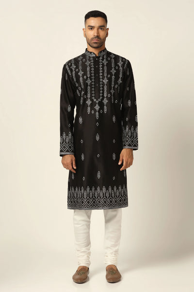 Elevate your ethnic look with this Chanderi silk kurta pajama set. The black kurta features striking hand embroidery, paired with off-white churidar pajamas for a timeless appeal.