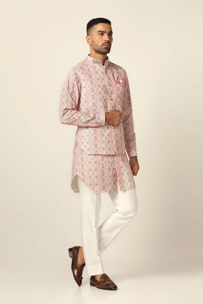 Make a statement in our Nehru set adorned with geometric pattern print and intricate mirror work. Paired with a matching kurta and off-white trousers for a bold yet elegant look.