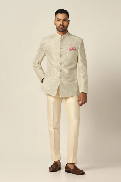 Drape in elegance with our raw silk Bandhgala suit. The coat features intricate hand embroidery, blending Thread and Zari work, paired with matching off-white trousers.