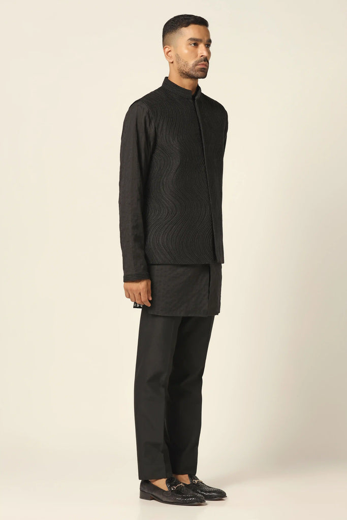 Elevate your ensemble with our Nehru Jacket set featuring meticulous machine & hand embroidery. Paired with a matching kurta and jet-black trousers for timeless sophistication.