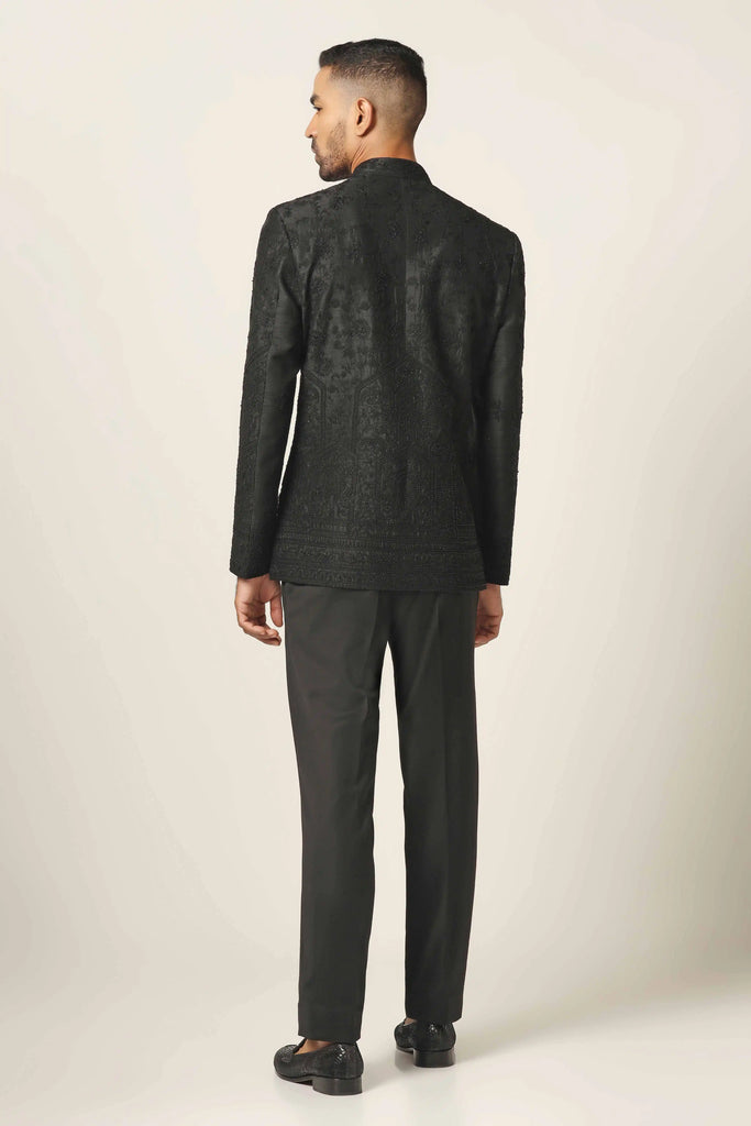 Elevate your style with our raw silk black Bandhgala. Intricately embroidered coat paired with tapered trousers for a refined ensemble.