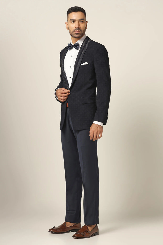 Distinguished style in our Textured Navy Blue Tuxedo. Shawl collar, subtle embroidery on the coat. Jet black Trouser completes the ensemble.
