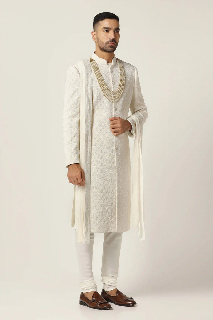 Drape in luxury with our Raw silk Sherwani set, intricately hand-embroidered throughout. This ensemble includes the classic Kurta & Pajama for timeless elegance.