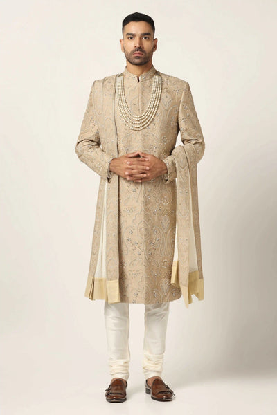 Immerse yourself in luxury with our Raw silk Sherwani set, adorned with exquisite hand embroidery throughout. Includes Kurta & Pajama for a complete ensemble.