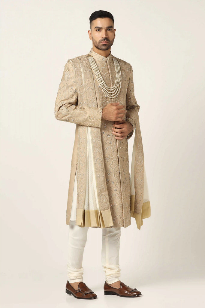 Immerse yourself in luxury with our Raw silk Sherwani set, adorned with exquisite hand embroidery throughout. Includes Kurta & Pajama for a complete ensemble.