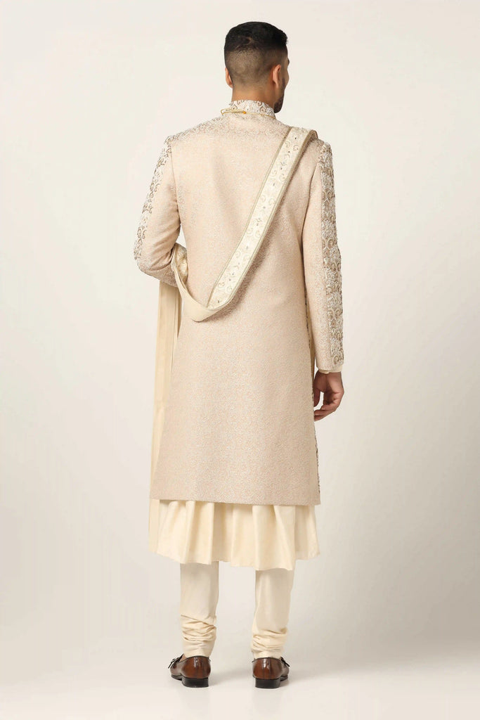 Elevate your style with our beige Sherwani, adorned with floral and geometric embroidery. Complete with a pleated Kurta and Pajama set for timeless elegance.