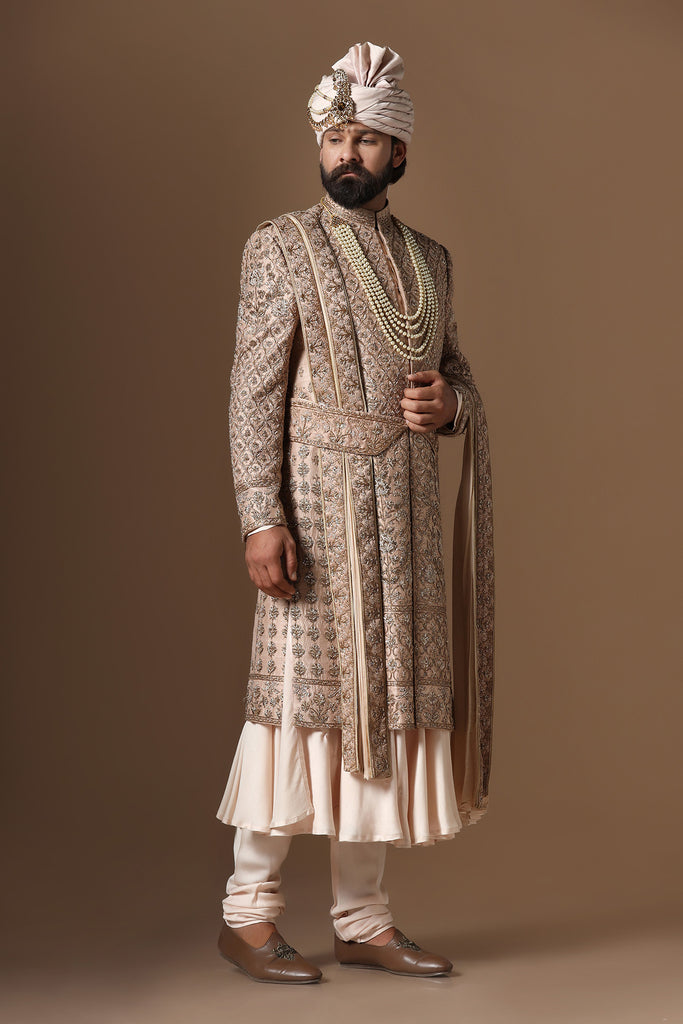 Experience our best-selling sherwani, adorned with captivating floral and geometric embroidery. Paired with a pleated kurta and pajama set for unmatched elegance.
