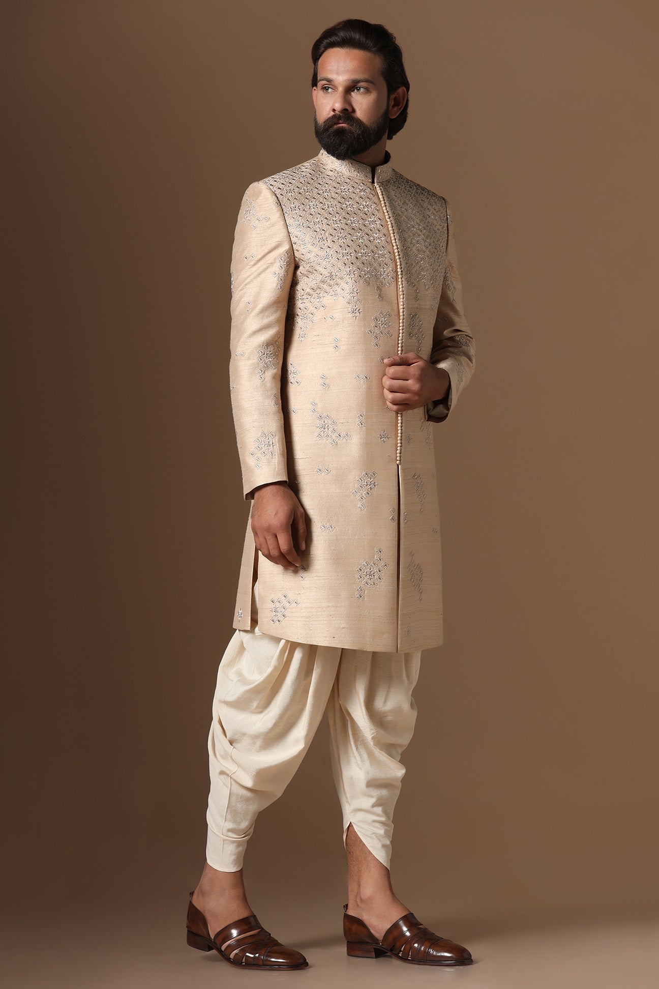 This beige Indo-Western made with raw silk fabric is highlighted by intricate embroidery. Shop Now!