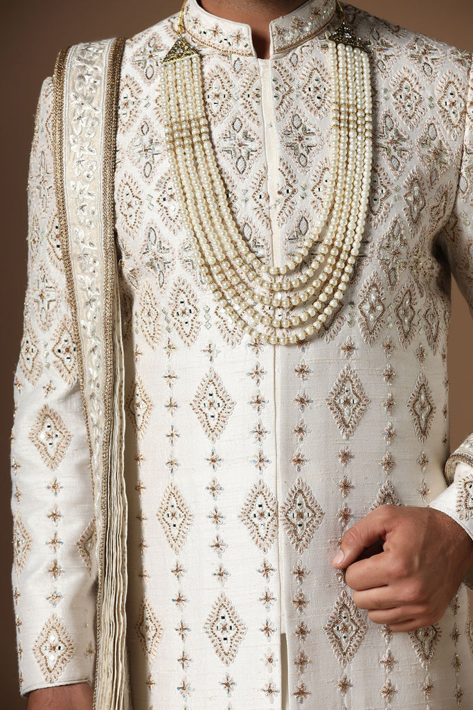 Elevate your style with this elegant Raw-Silk Sherwani, featuring captivating geometric embroidery. A timeless statement of sophistication.