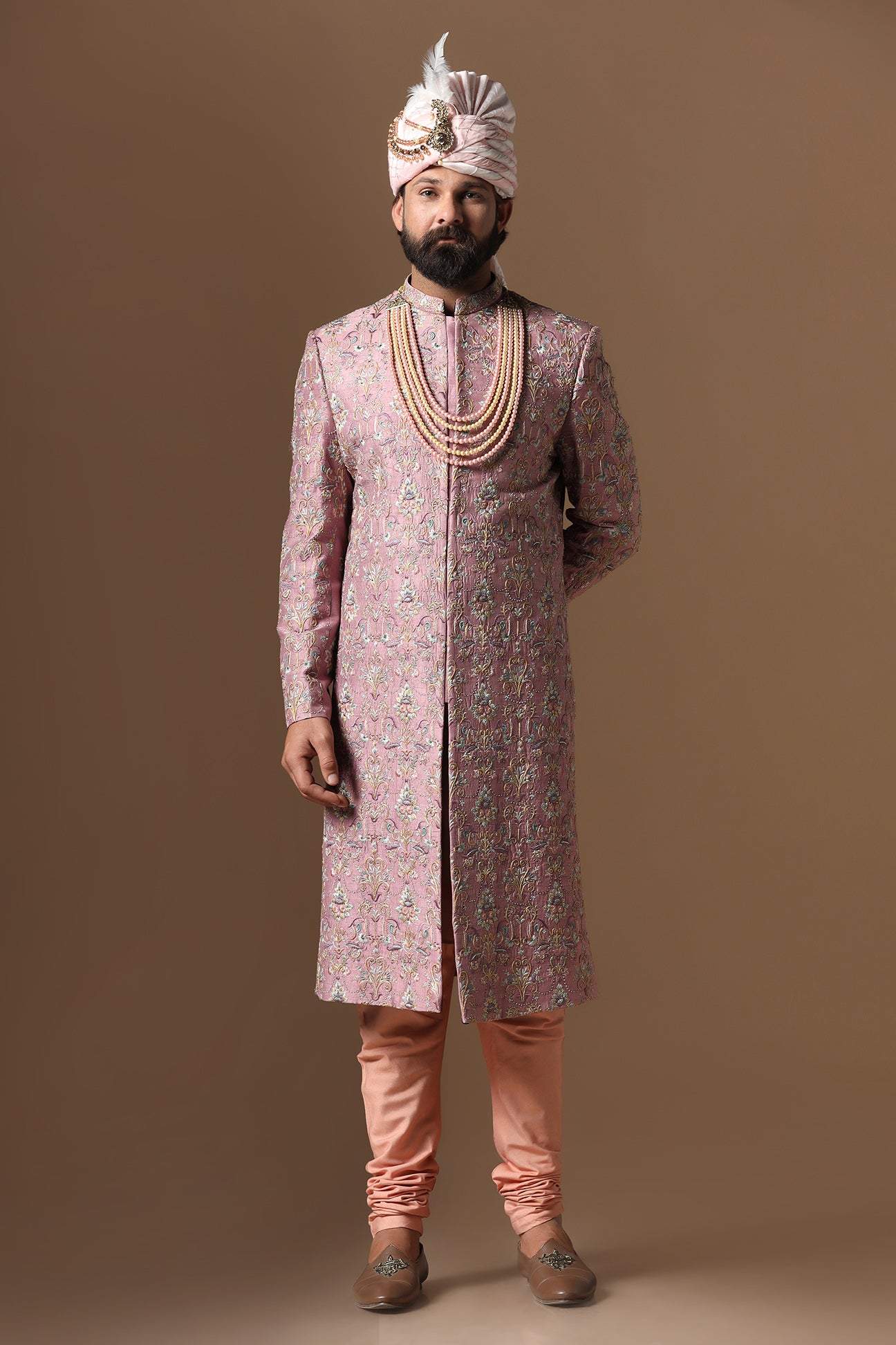 This pink embroidered Sherwani blends floral and geometric embroidery patterns. Shop Now!