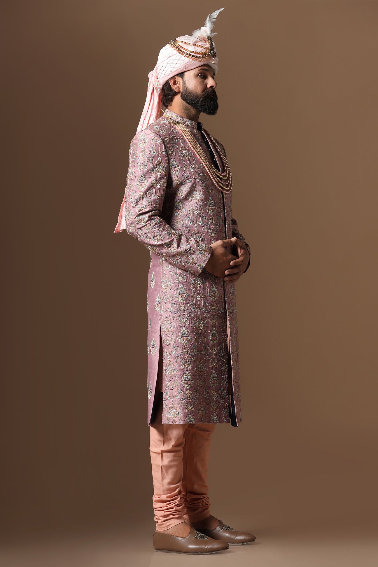This pink embroidered Sherwani blends floral and geometric embroidery patterns. Shop Now!
