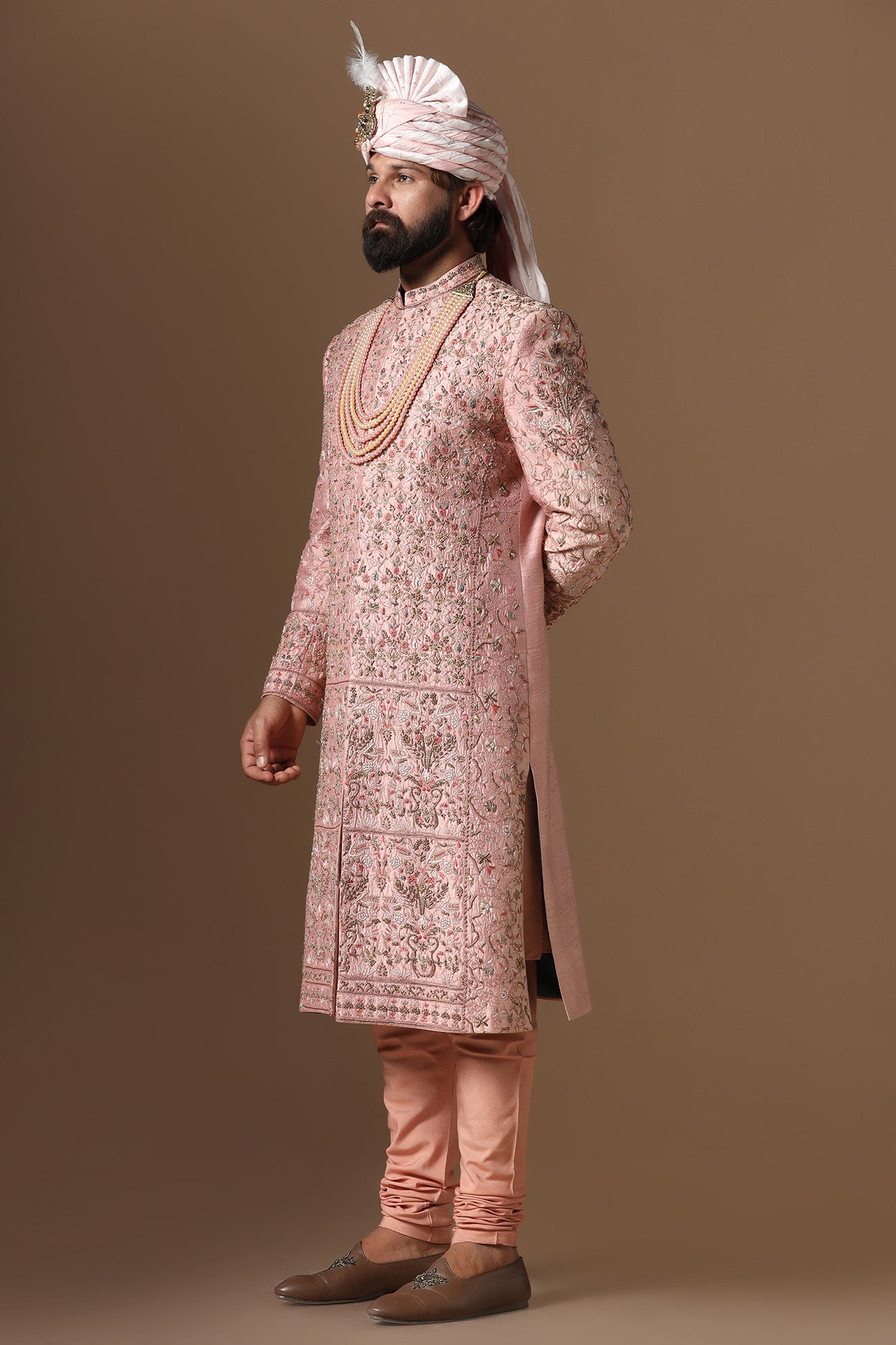 This peach Sherwani is highlighted by intricate floral embroidery across the garment. Shop Now!