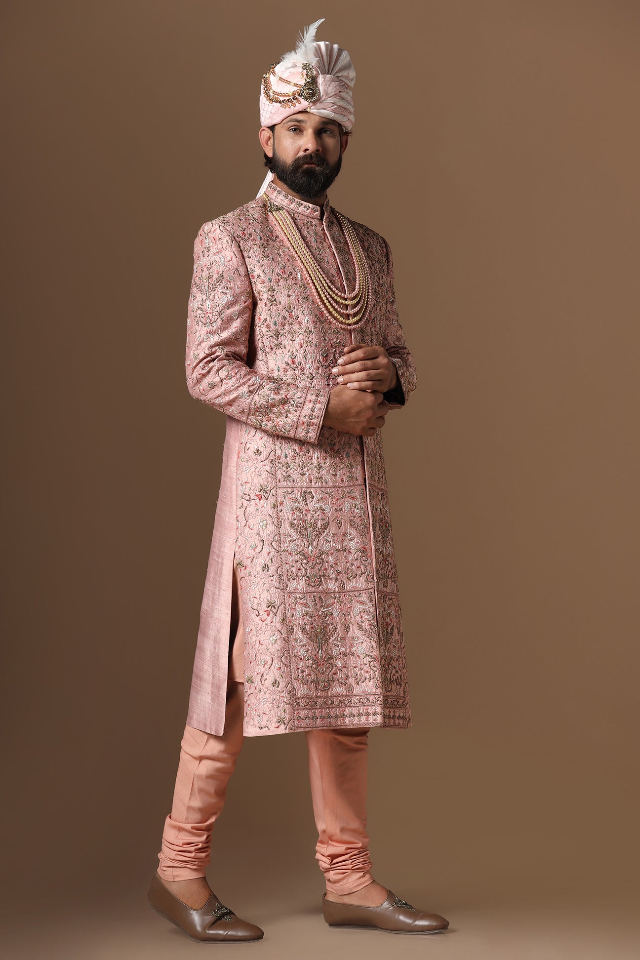 This peach Sherwani is highlighted by intricate floral embroidery across the garment. Shop Now!