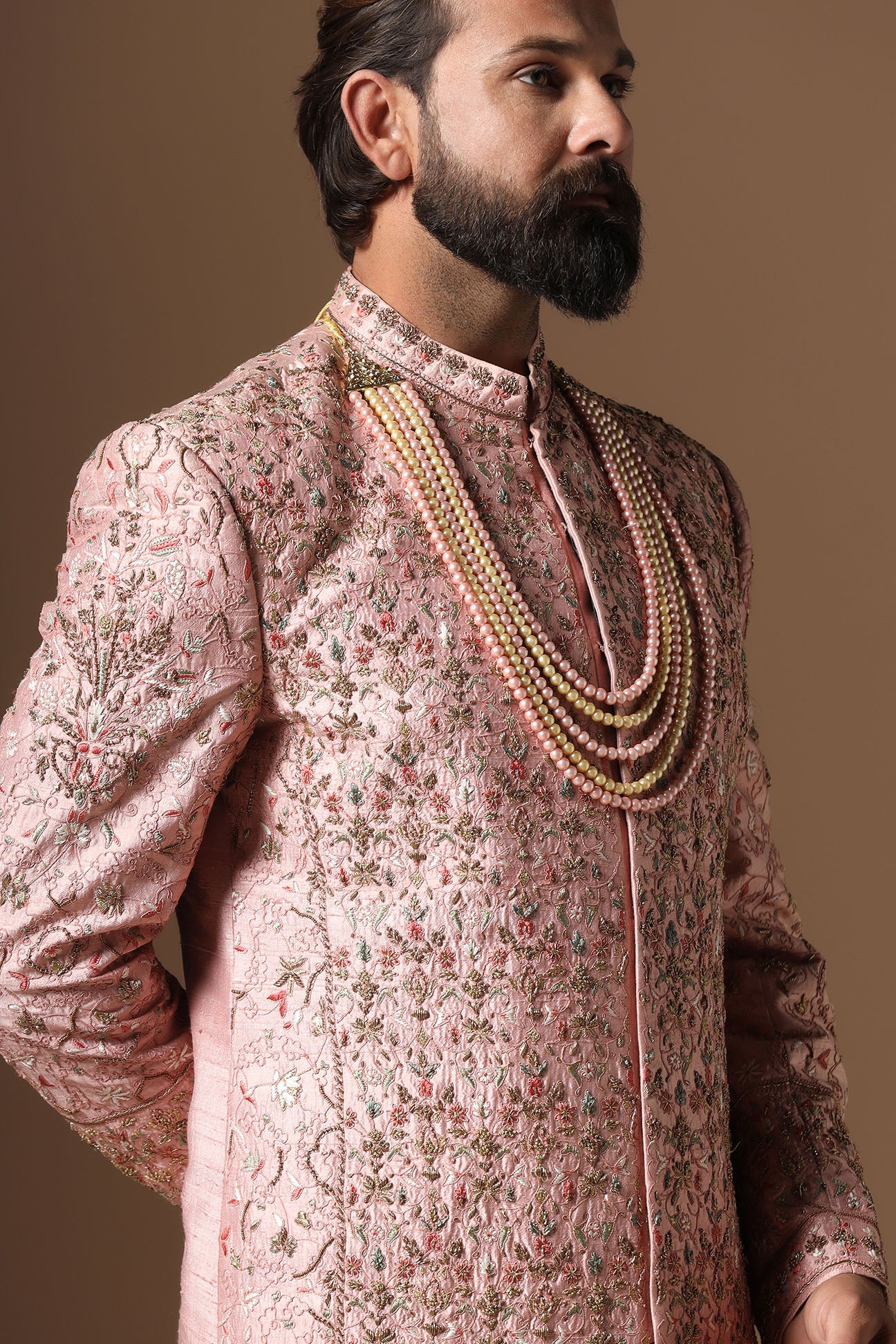 This peach Sherwani is highlighted by intricate floral embroidery across the garment. Shop Now!