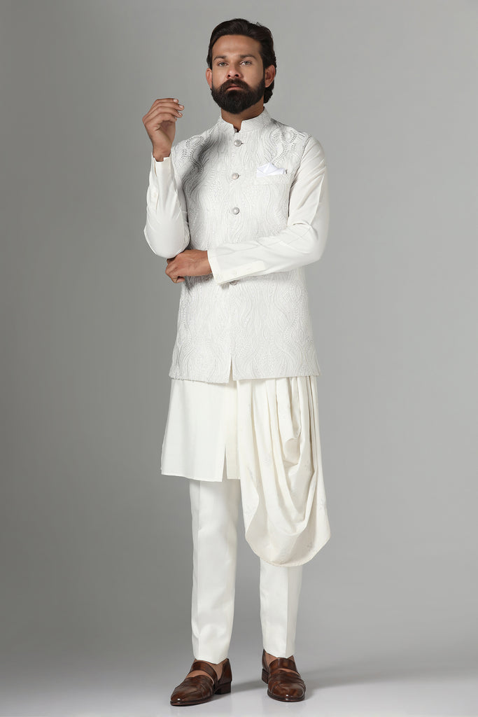 Embrace elegance with our off-white Nehru jacket featuring tonal embroidery. Complete with a draped kurta and pajama set for a refined ensemble.