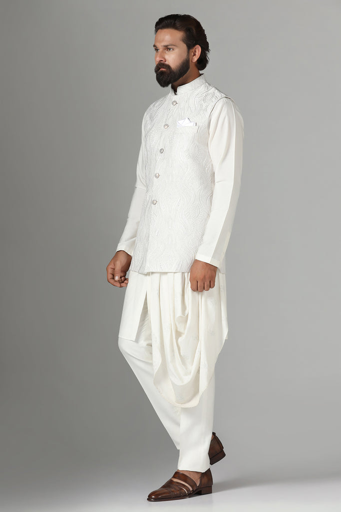 Embrace elegance with our off-white Nehru jacket featuring tonal embroidery. Complete with a draped kurta and pajama set for a refined ensemble.