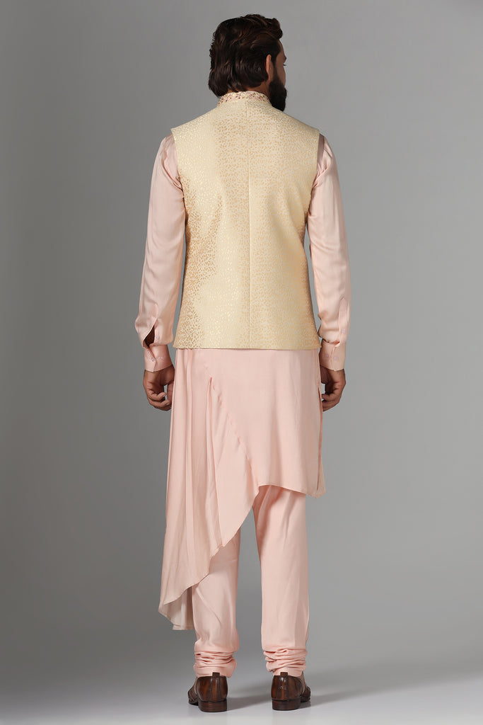 Elevate your ensemble with this exquisite golden jacquard Nehru jacket, featuring intricate thread embroidery on the neckline and pocket bone, paired with a draped kurta and pajama set.