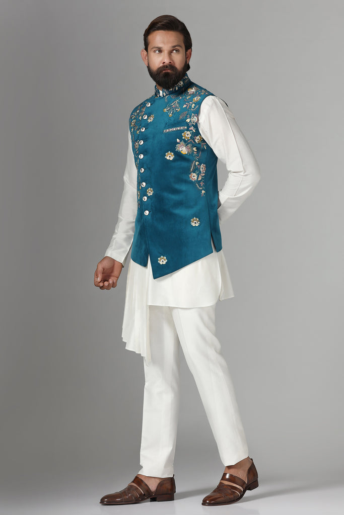Step into elegance with our velvet Nehru jacket, boasting asymmetric floral embroidery. Paired with a pleated kurta and pajama set for a refined ensemble.
