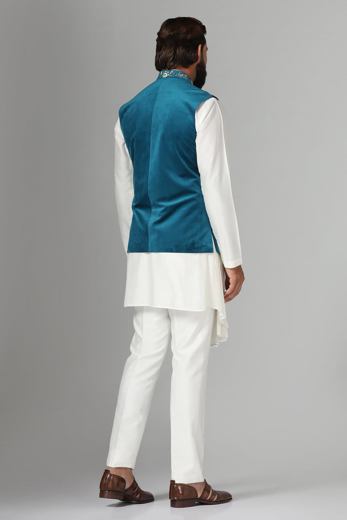Step into elegance with our velvet Nehru jacket, boasting asymmetric floral embroidery. Paired with a pleated kurta and pajama set for a refined ensemble.