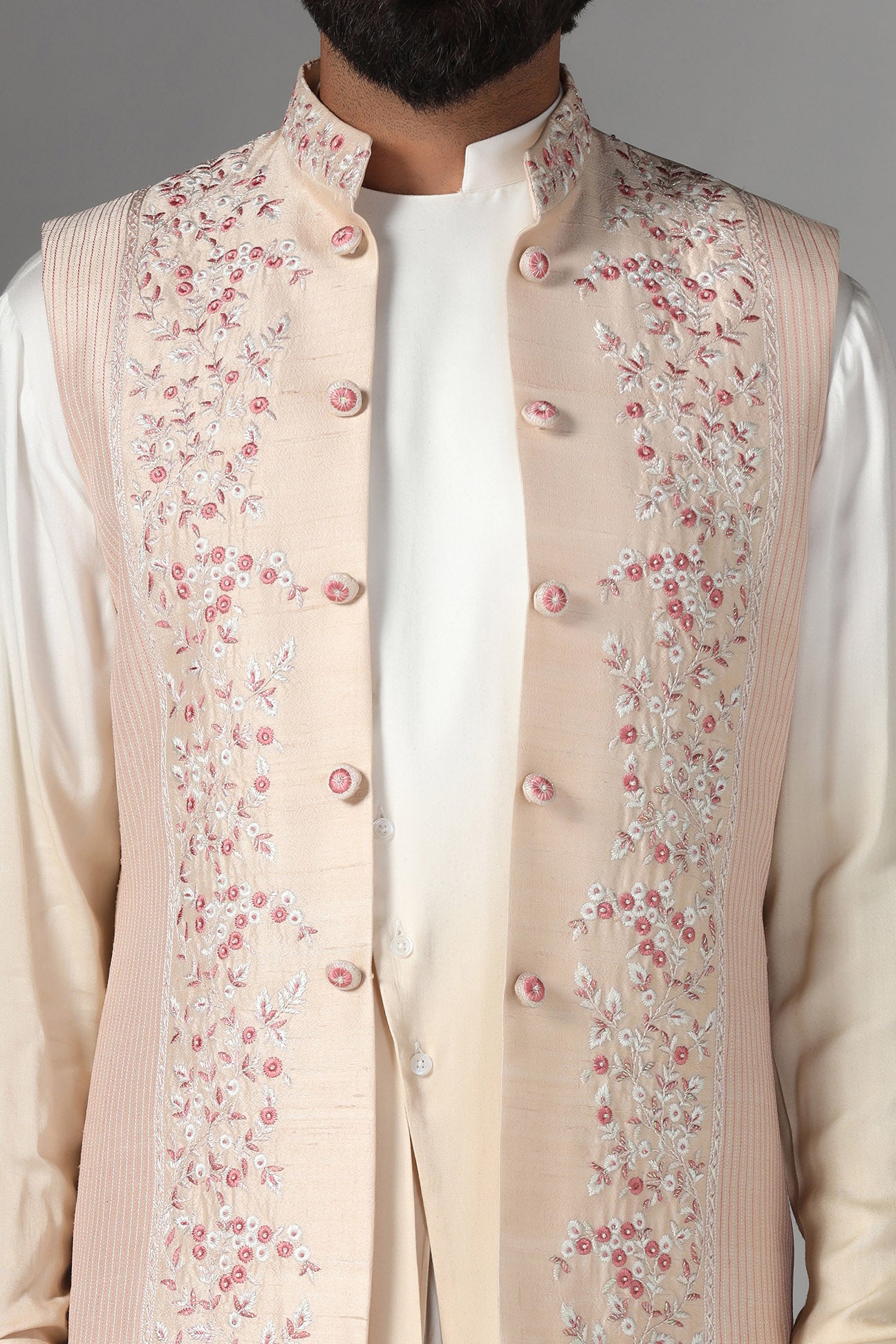 Elevate style with our light peach raw silk Nehru Jacket adorned with floral embroidery. Shop Now!