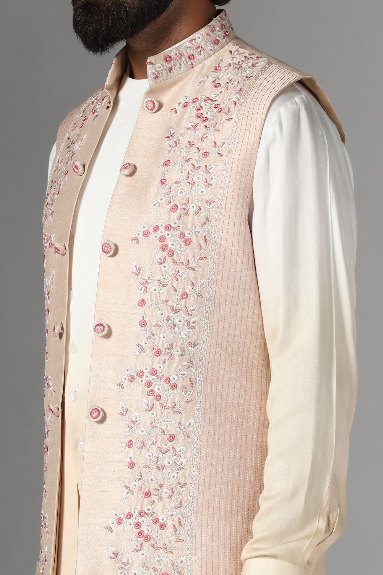 Elevate style with our light peach raw silk Nehru Jacket adorned with floral embroidery. Shop Now!