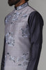 Enhance your style with our grey raw silk Nehru jacket adorned with floral embroidery. Paired with a black asymmetric kurta pajama for a striking ensemble.