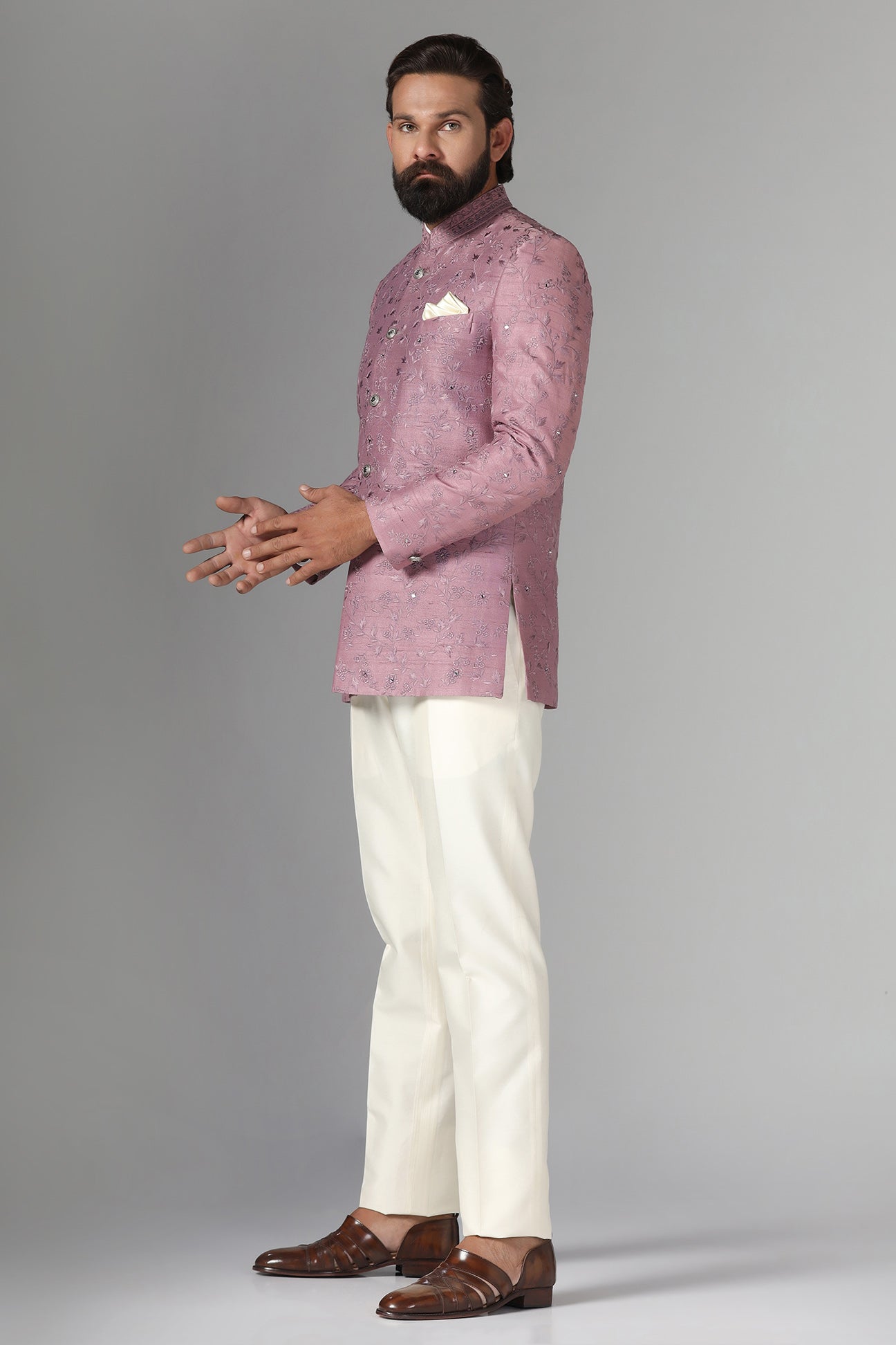 Elevate your style with our onion-pink Bandhgala suit in raw-silk fabric, adorned with floral embroidery. Shop Now!