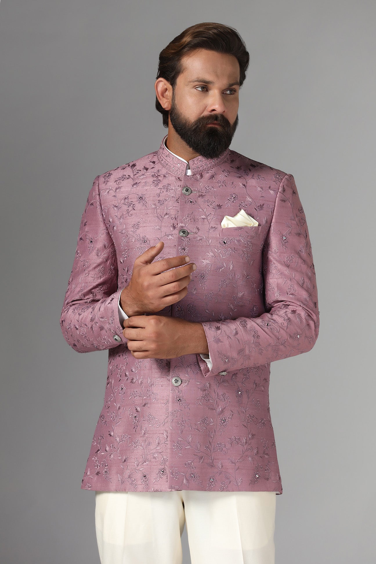 Elevate your style with our onion-pink Bandhgala suit in raw-silk fabric, adorned with floral embroidery. Shop Now!
