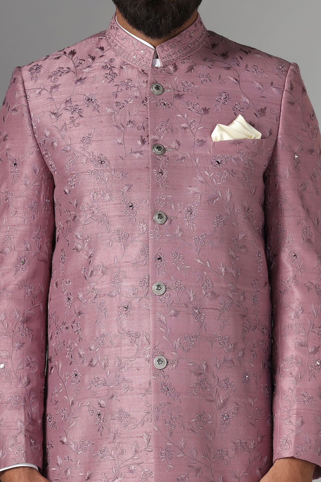 Elevate your style with our onion-pink Bandhgala suit in raw-silk fabric, adorned with floral embroidery. Shop Now!