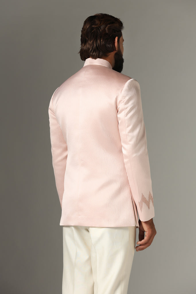 Radiate elegance in our light pink textured Bandhgala suit, paired with off-white trousers for a timeless ensemble.