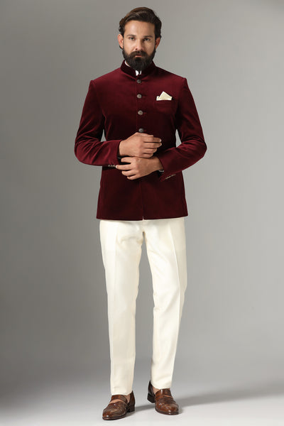 Step into sophistication with our maroon Bandhgala suit in rich velvet fabric, accentuated by a contrast metal button closure. Trousers feature a tapered, flat-front design.