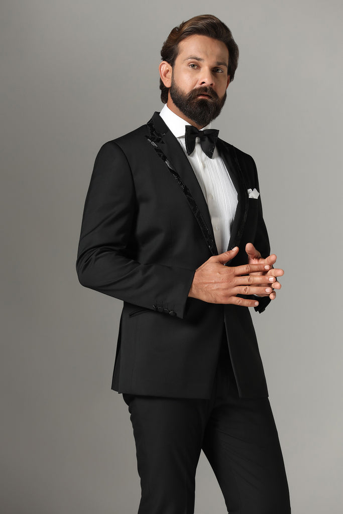 Refined sophistication in our Jet Black Tuxedo. Peak lapel with subtle embroidery. Crafted from wool-rich fabric, paired with Jet-Black trousers.