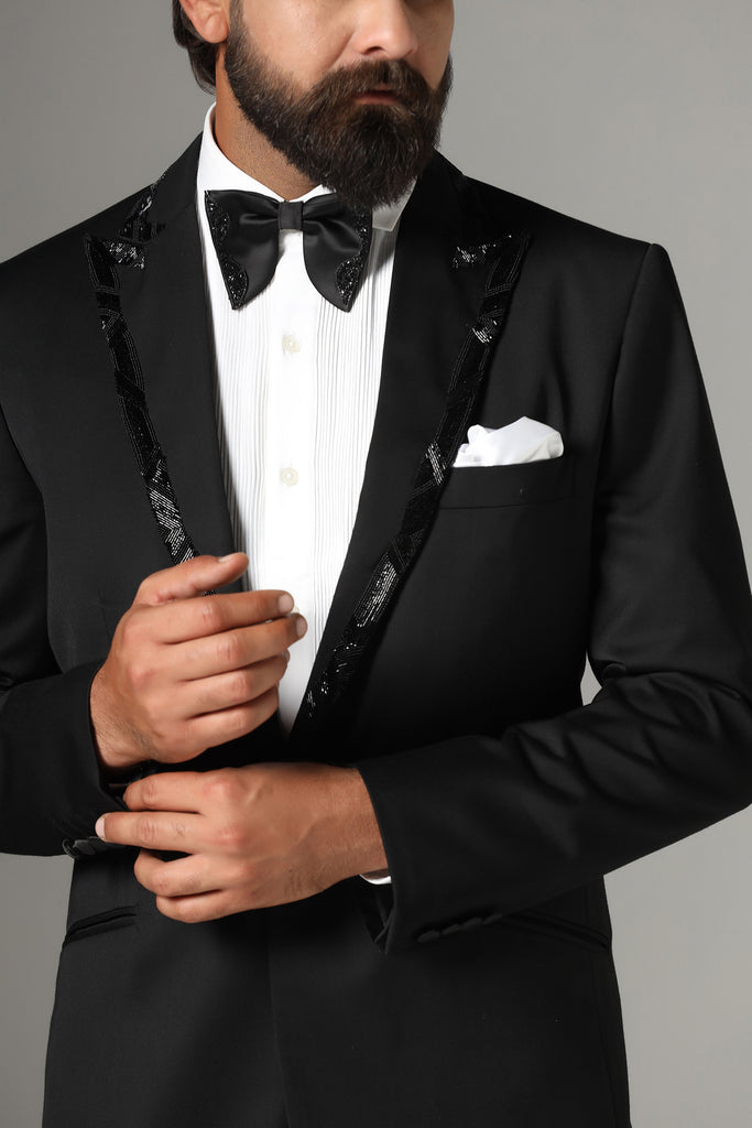 Refined sophistication in our Jet Black Tuxedo. Peak lapel with subtle embroidery. Crafted from wool-rich fabric, paired with Jet-Black trousers.