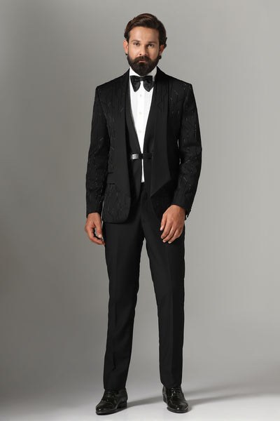 Elevate your style with our Black Three-Piece Tuxedo. Intricate embroidery throughout, modern cut shawl lapel. Accessories sold separately.