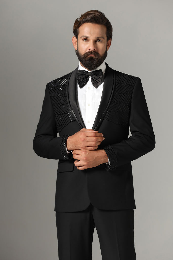 Distinguished elegance in our Black Embroidered Tuxedo. Shawl collar adorned with subtle embroidery. Crafted from wool-rich fabric, paired with Jet-Black trousers.