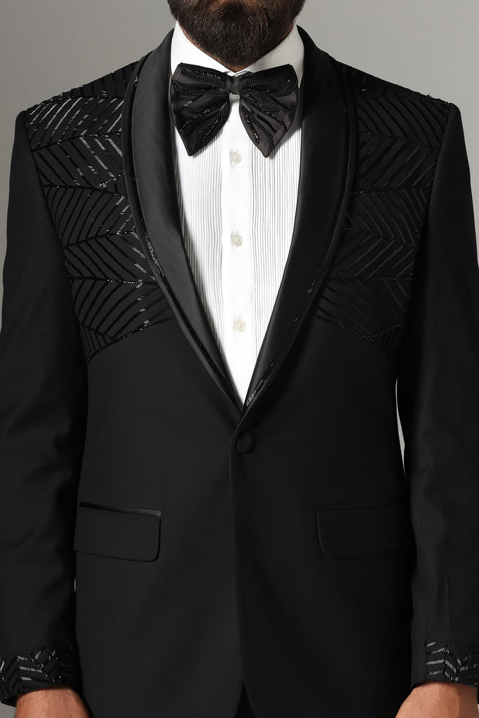 Distinguished elegance in our Black Embroidered Tuxedo. Shawl collar adorned with subtle embroidery. Crafted from wool-rich fabric, paired with Jet-Black trousers.